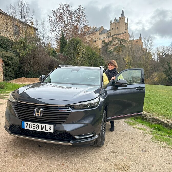 Influencer die in Honda HR-V stapt bij een kasteel. 