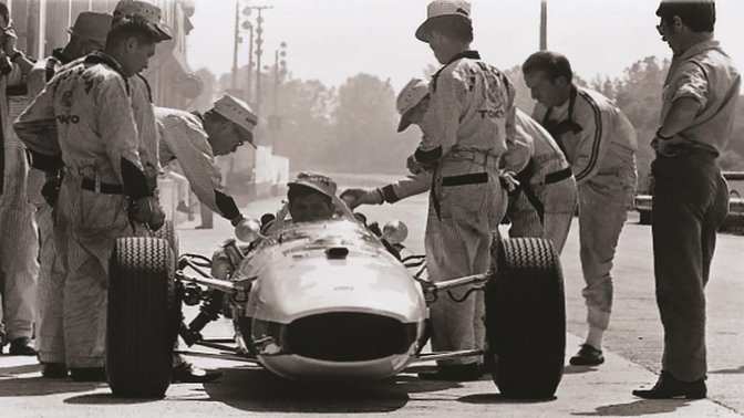 Vooraanzicht van Honda Formule 1 auto uit de jaren zestig met coureur en ontwerpers.