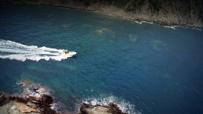 Luchtfoto van boot die door de zee vaart.