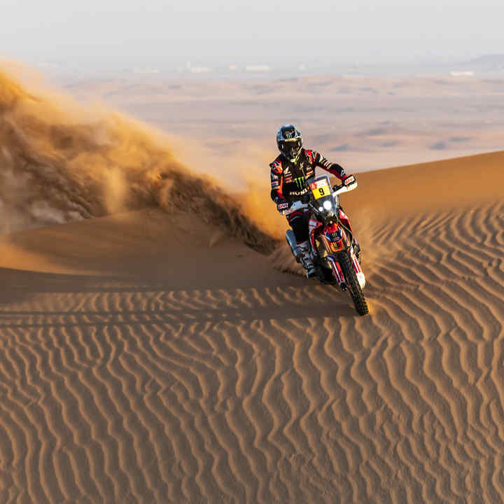 Dakar-rijder van Honda in de woestijnduinen. 