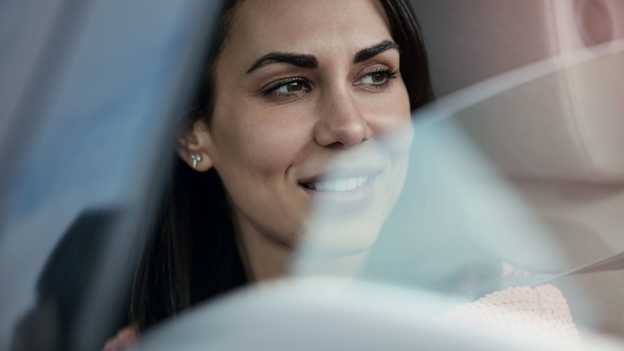 Close-up van vrouw die uit een open autoraam staart