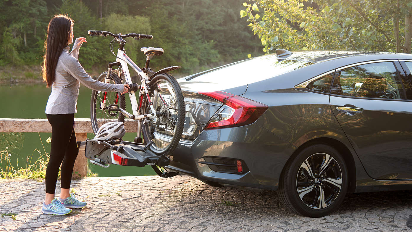 Zijaanzicht van model met Thule fietsdrager in een bos