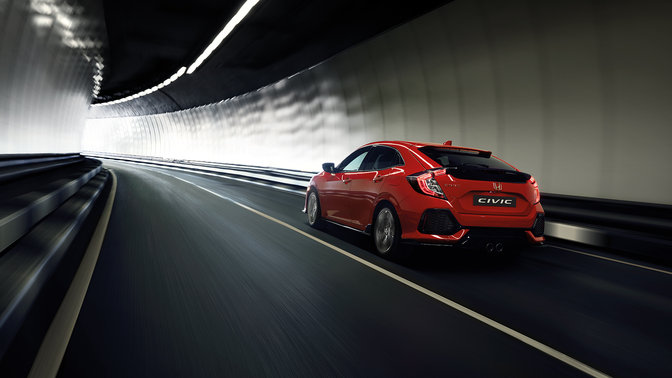 Driekwart achteraanzicht van Honda Civic die door tunnel rijdt.