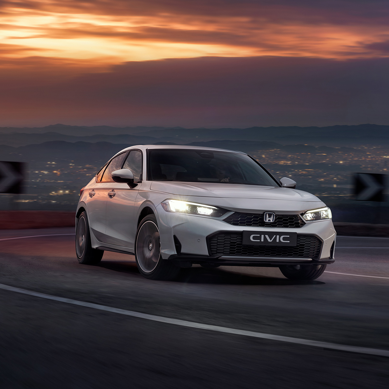 Honda Civic Hybrid in beweging op een snelweg, in de schemering.