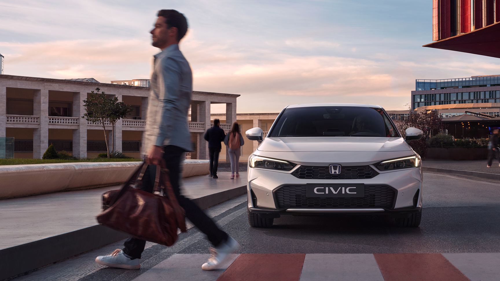 Honda Civic Hybrid nadert een man voor een zebrapad.