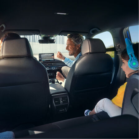 Beeld vanaf de achterbank van een gezin in de auto.