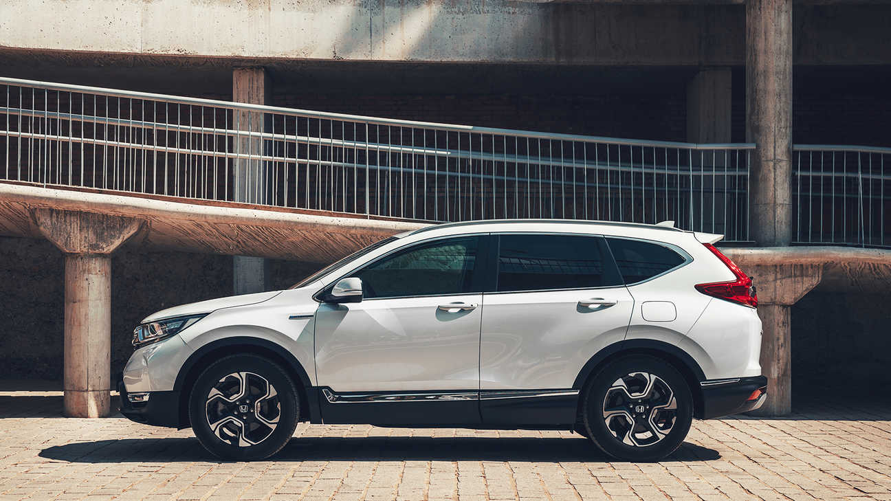 Zijvooraanzicht Honda CR-V Hybrid in stadslocatie.