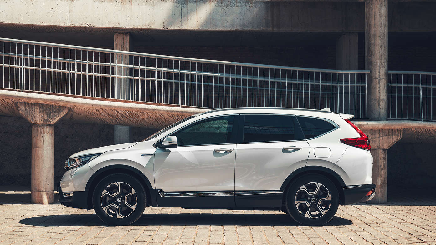 Zijvooraanzicht Honda CR-V Hybrid in stadslocatie.