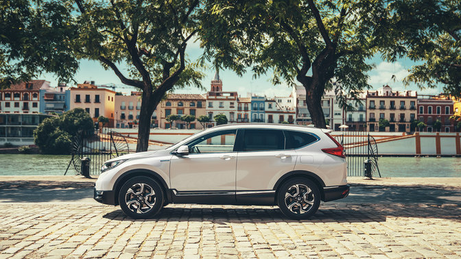 Zijvooraanzicht Honda CR-V Hybrid in stadslocatie.
