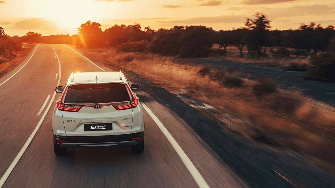 Driekwart achteraanzicht Honda CR-V Hybrid op woestijnlocatie.