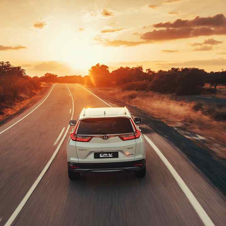 Driekwart achteraanzicht Honda CR-V Hybrid op woestijnlocatie.