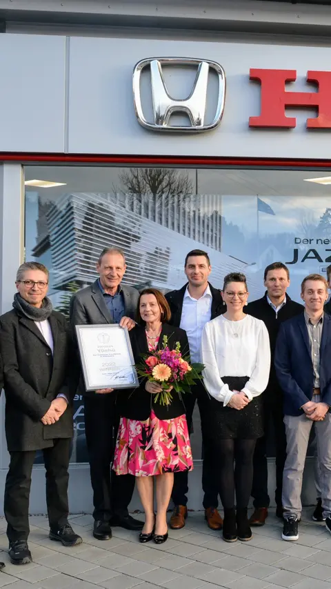 Groep dealers viert hun Yūshū-dealerprijs.