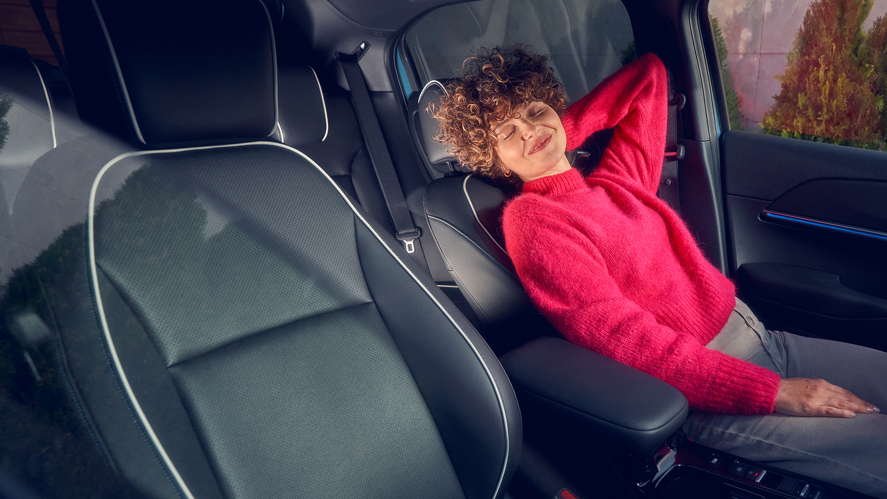 Vrouw achteroverliggend in de bestuurderszetel van de Honda e:NY1.