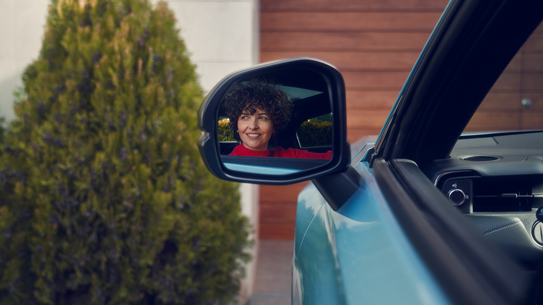 De reflectie van een vrouw in de buitenspiegel van de Honda e:Ny1.