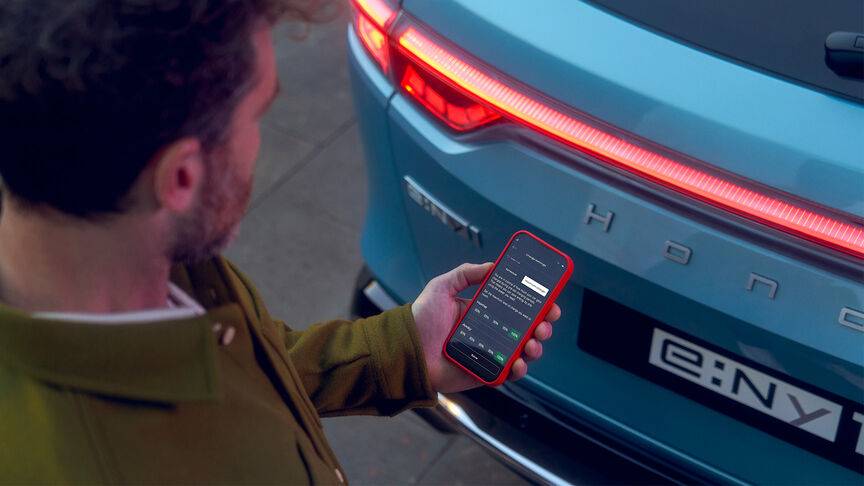 Dame naast witte Honda e gebruikt My Honda+ app