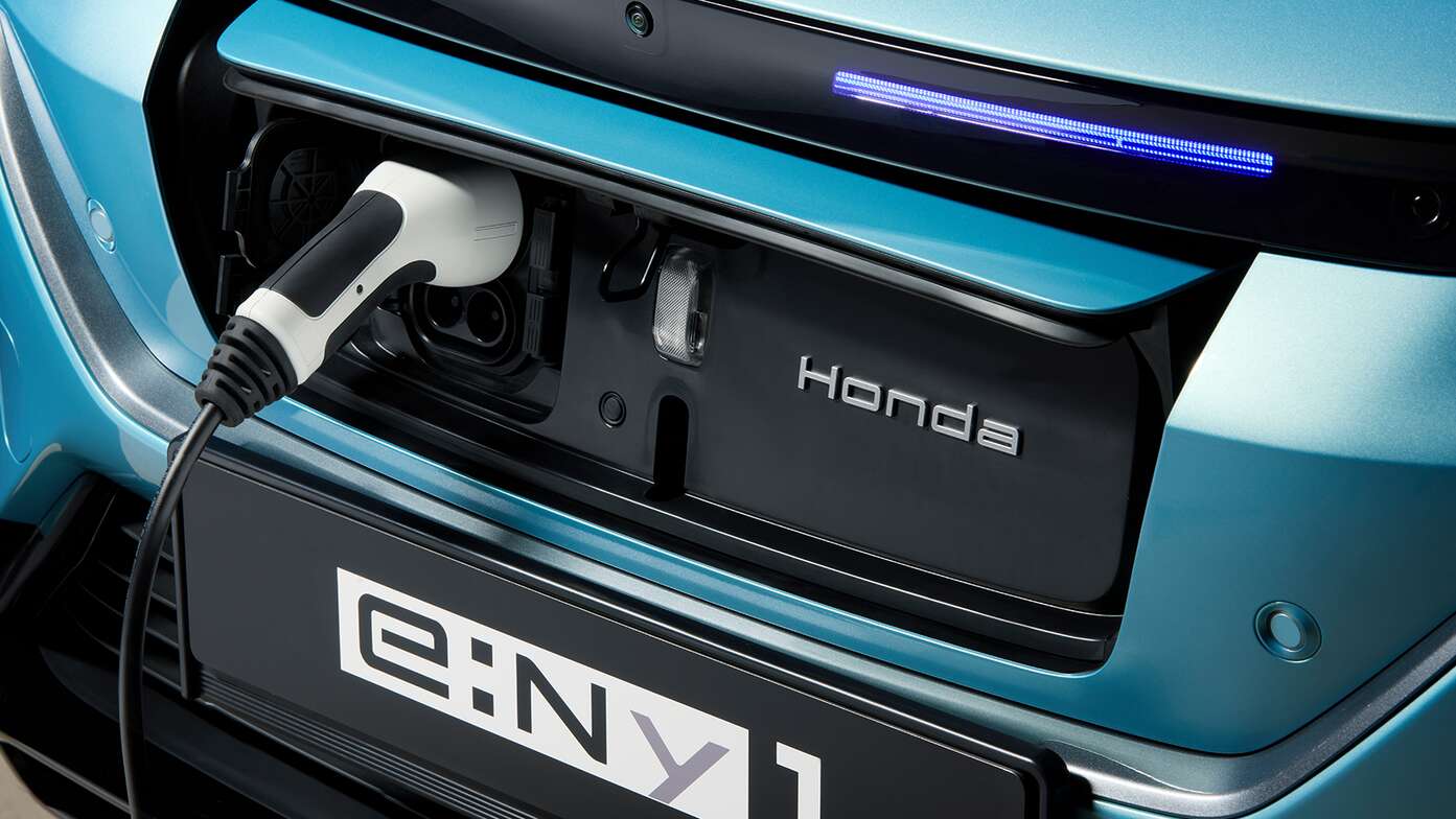 Close up van Honda e:Ny1 Makkelijk toegankelijke laadpoort aan de voorkant van de auto.