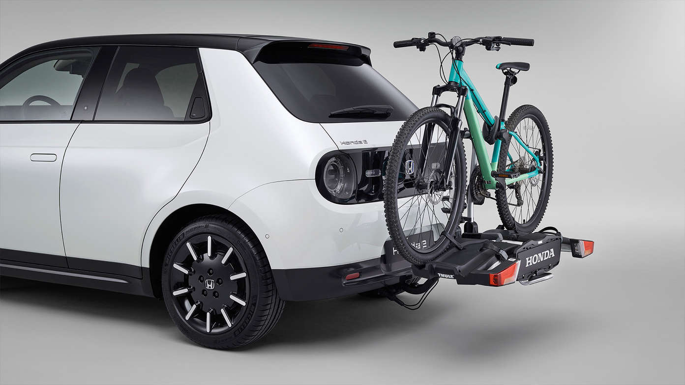 Driekwart achteraanzicht Honda e met afneembare fietsendrager.