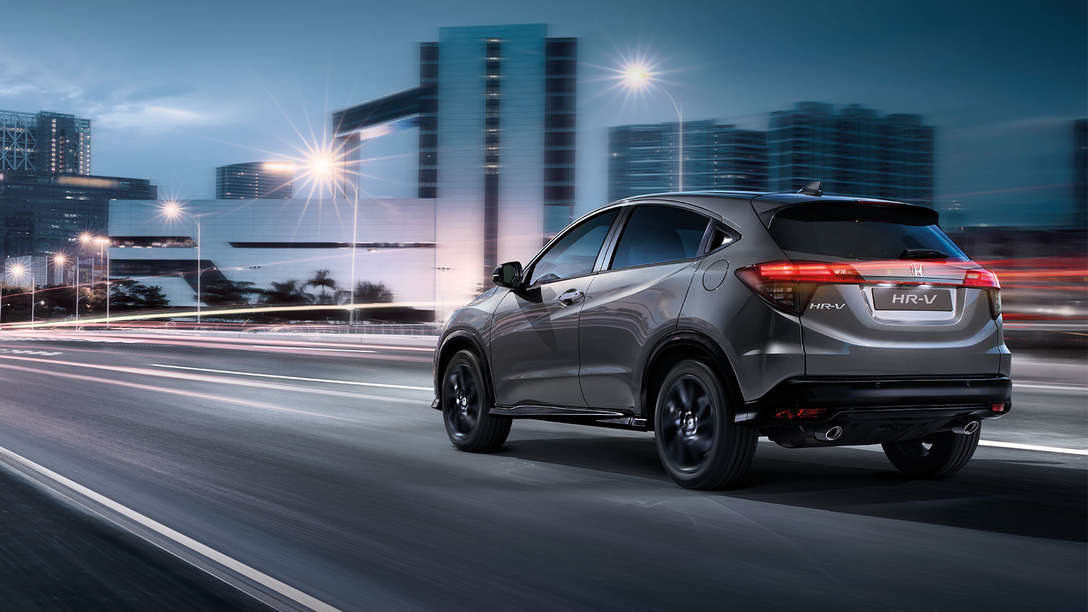 Driekwart achteraanzicht Honda HR-V Sport in de stad.
