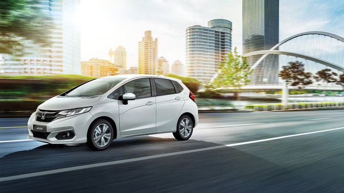 Frontaal driekwart zicht Honda Jazz op stadslocatie.