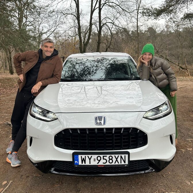 Twee influencers die op de Honda ZR-V leunen.