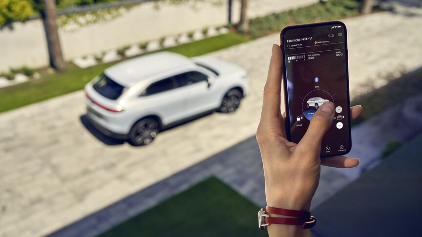 Dame naast witte Honda e gebruikt My Honda+ app