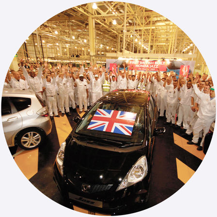 Bovenaanzicht van Honda Jazz met fabrieksmedewerkers.