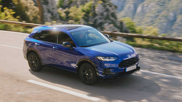 Blauwe Honda ZR-V Hybrid SUV onderweg in een bergachtige omgeving.