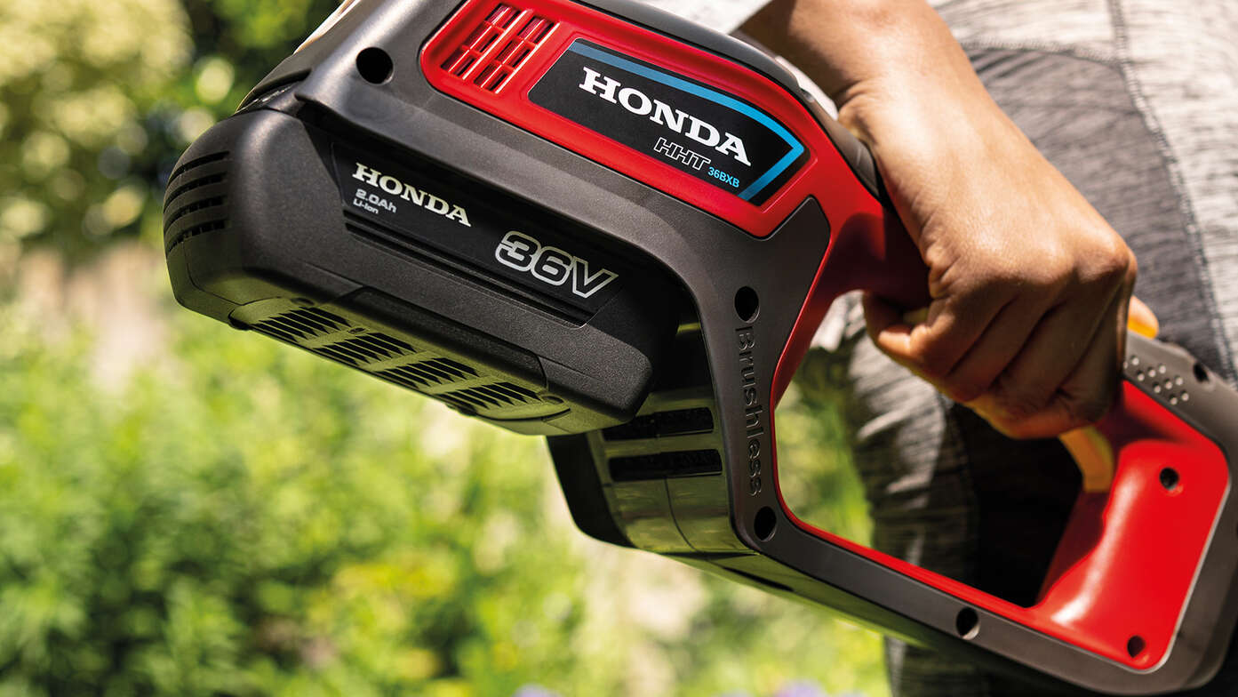 Close-up achteraanzicht van accu Honda grastrimmer in de tuin.