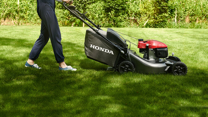  Zijaanzicht Honda HRN in een tuinomgeving.