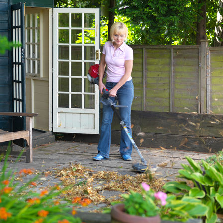 Honda Versatool met bladblazeropzetstuk, in gebruik door model, tuinlocatie.