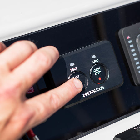 Close-up van start-stop knoppen van Honda buitenboordmotoren.