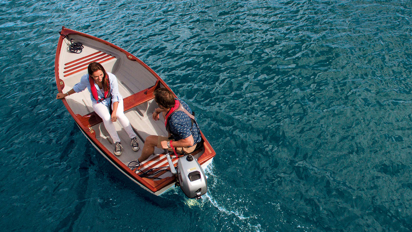 A man and a woman in a boat using the BF2.3 to power the boat forward