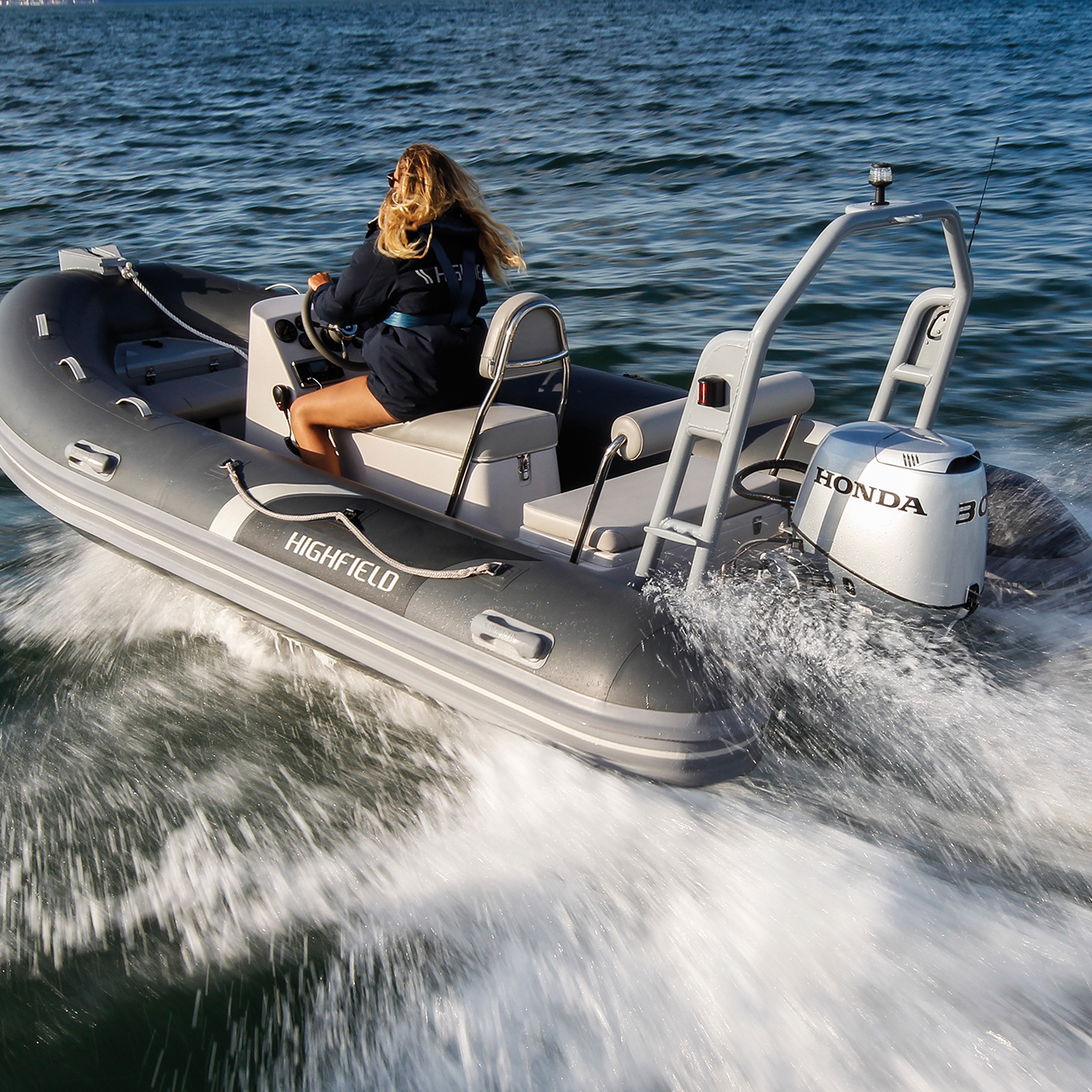 Dame op een Highfield-boot met een Honda BF30-motor op de oceaan.