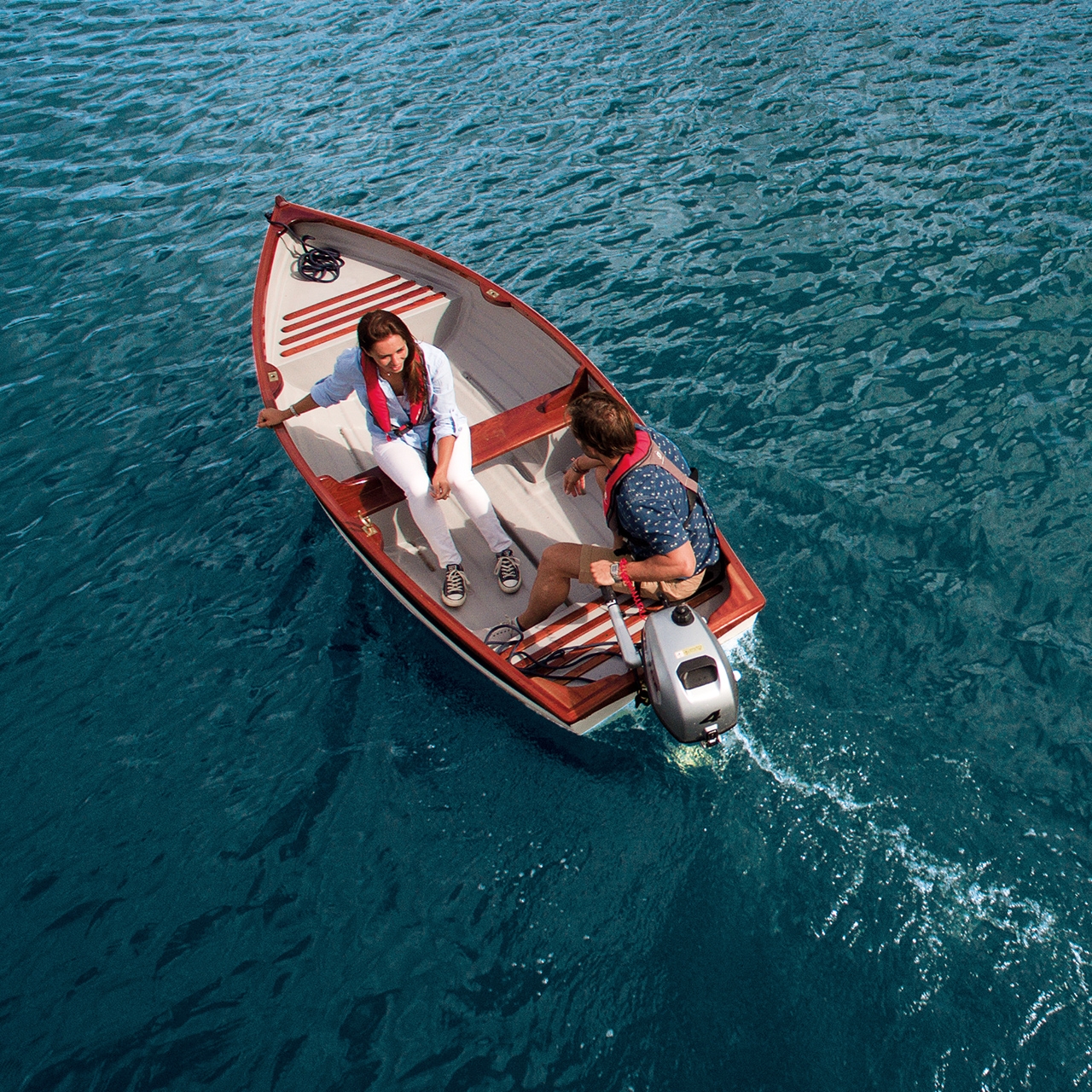 Koppel op een boot met Honda-motor op het water.