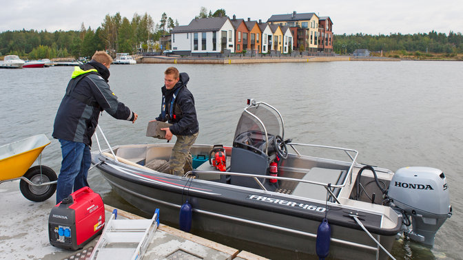 Boot met de BF50 motor, in gebruik door modellen, kustlocatie.