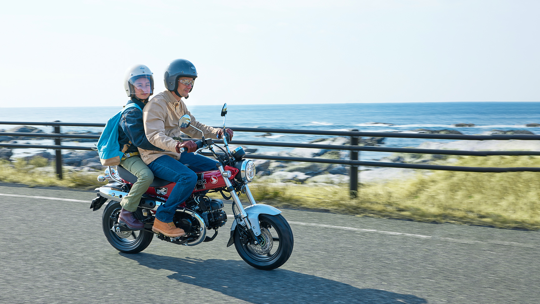 Honda Dax 125 op de kustweg met rijder en passagier