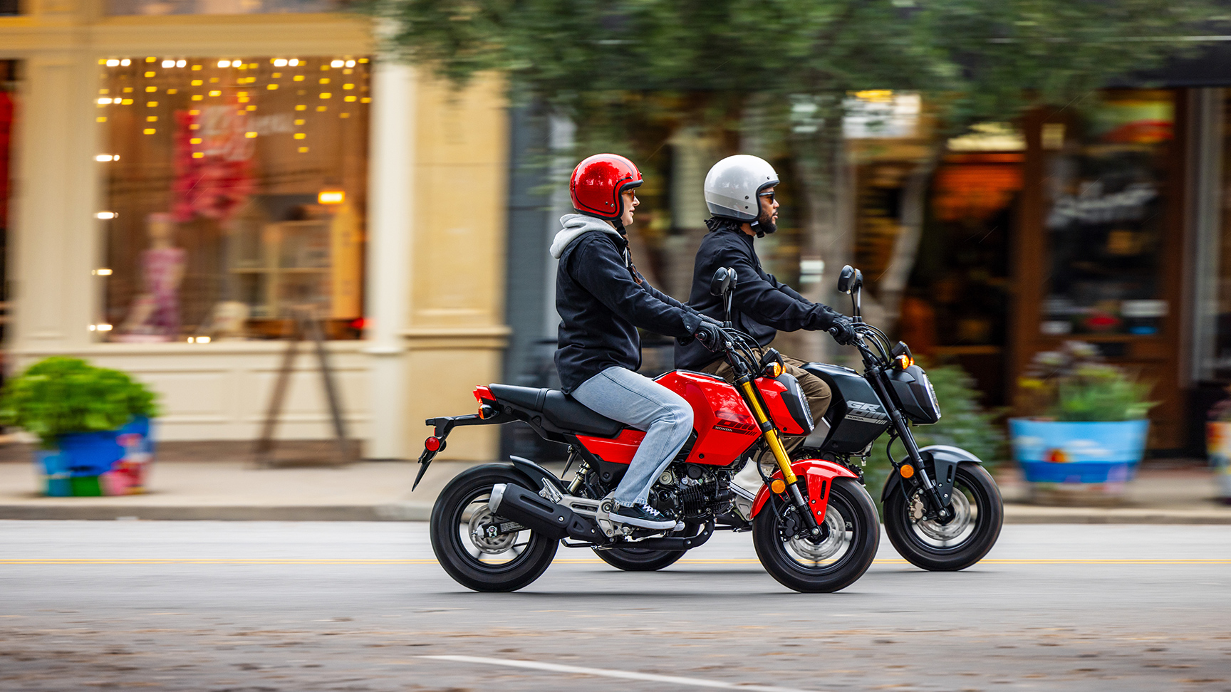 MSX125 Grom in zwart en rood die door de stad rijdt