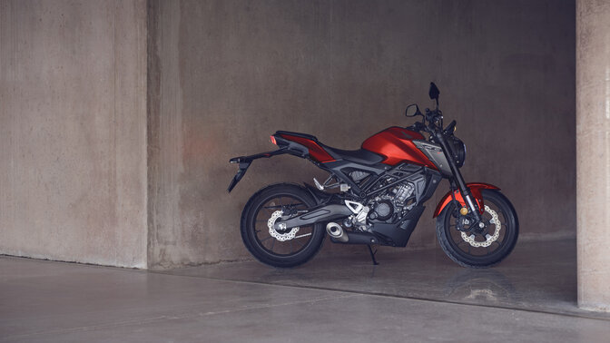 Honda Monkey op zijstandaard op de weg met rijder