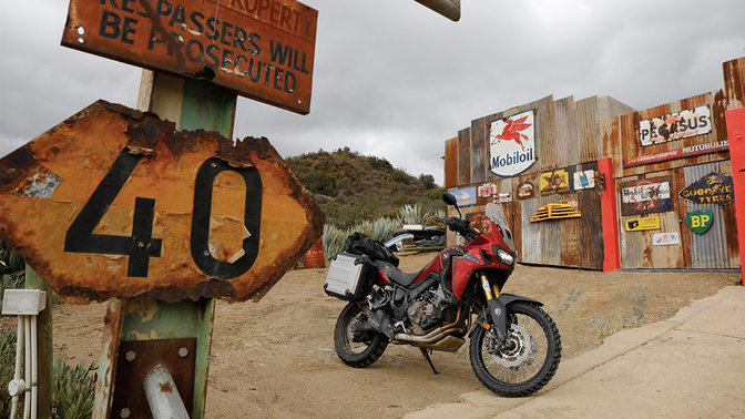 Honda CRF1000L Africa Twin geparkeerd aan tankstation langs de weg.