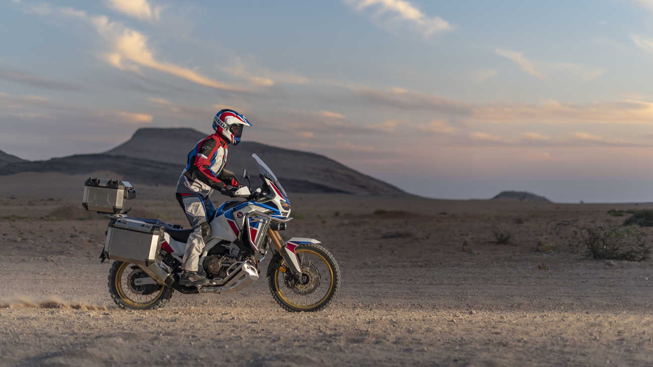 Honda Africa Twin Adventure sporten, rechterkant, rijdend op een onverharde weg door een woestijnlandschap