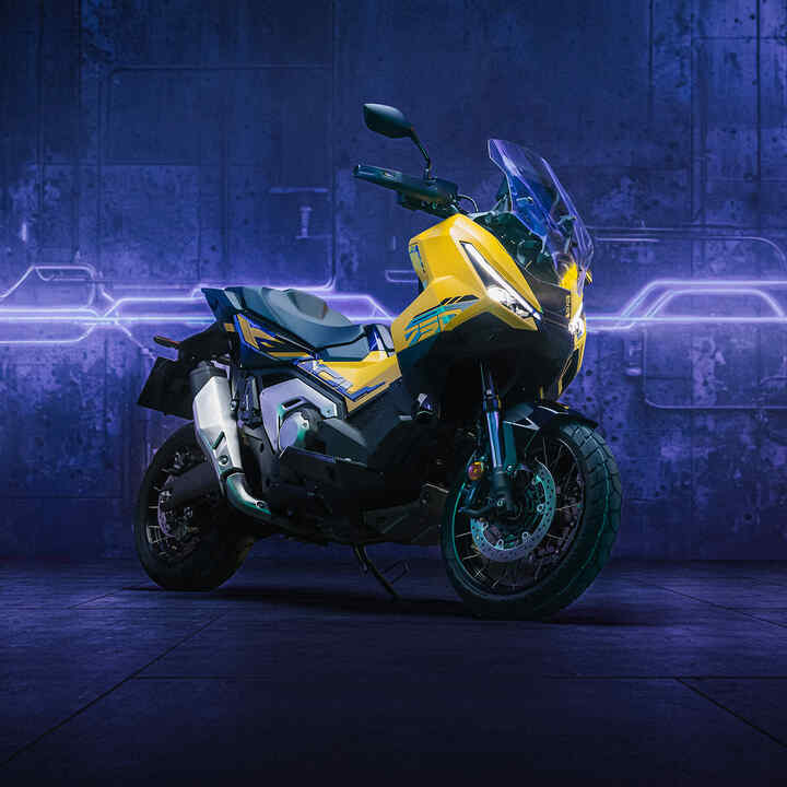 X-ADV special edition zijaanzicht met rijder in stedelijke omgeving