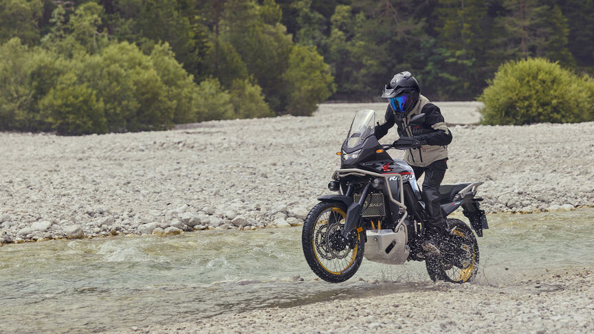 Model rijdend op XL750 Transalp in een bosomgeving.