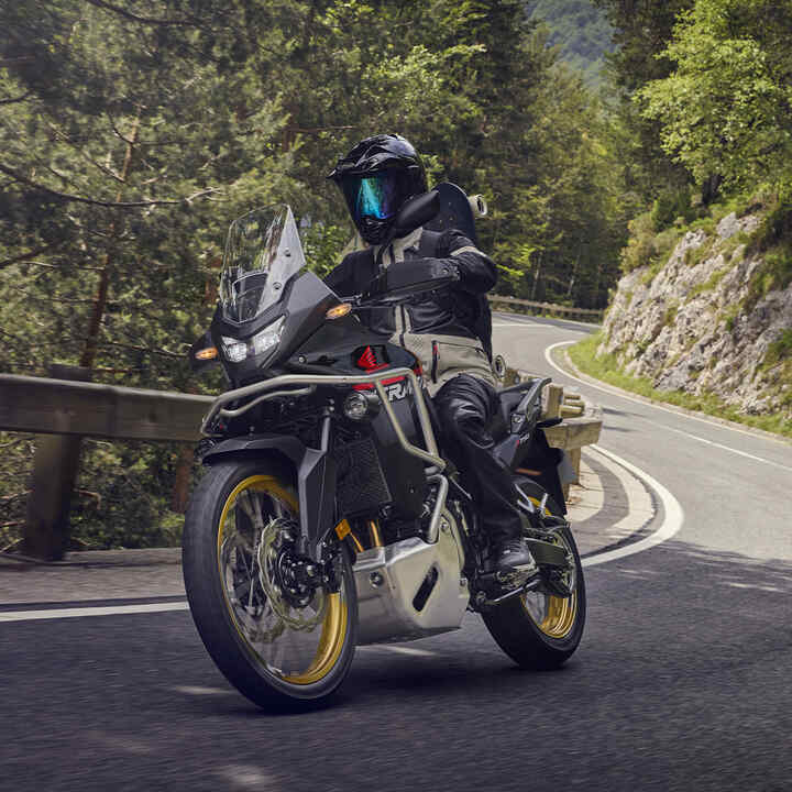 Model rijdend op de XL750 Transalp motorfiets in een berglandschap.