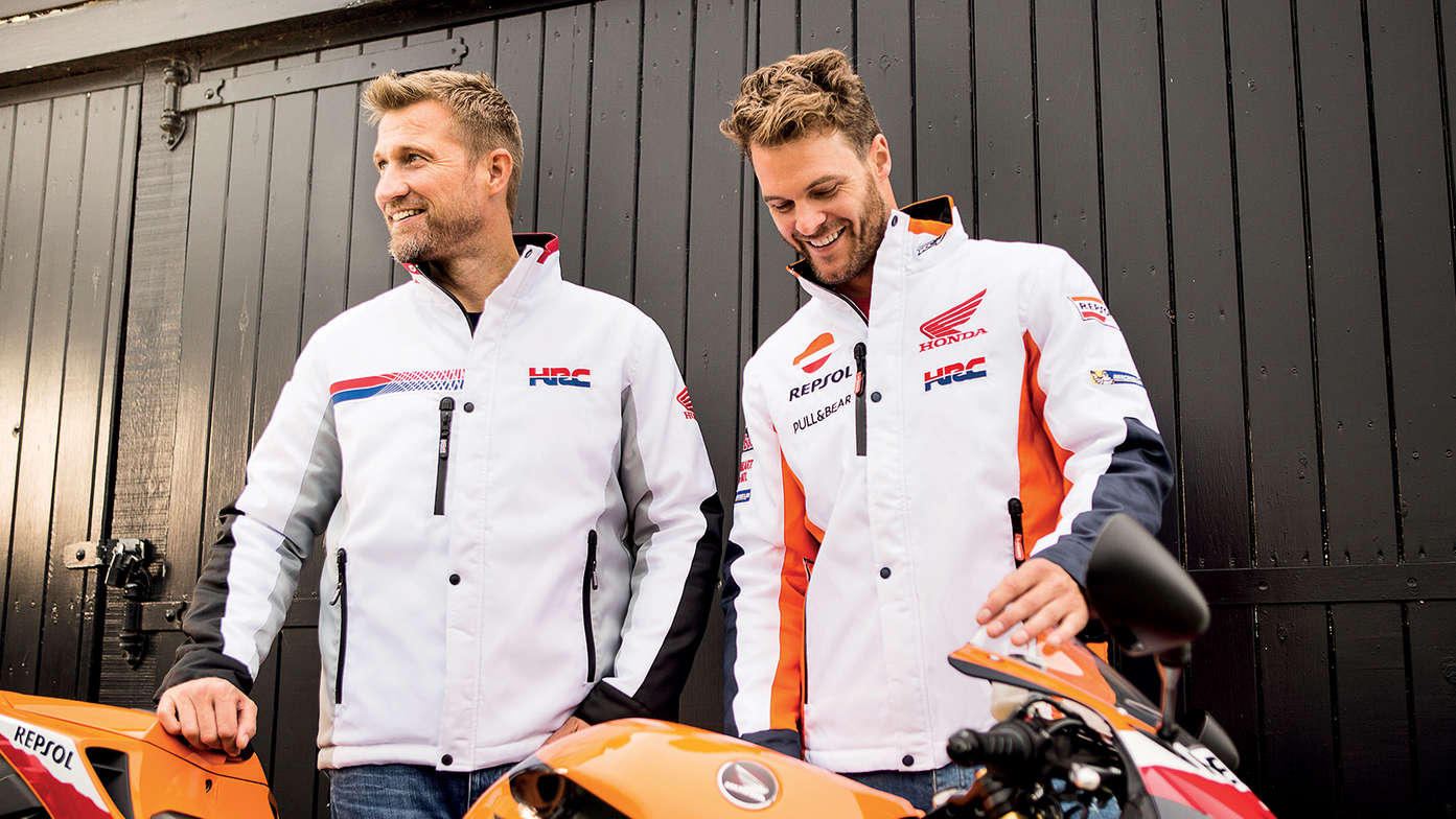 Twee lachende mannen met witte Honda racejassen lachen