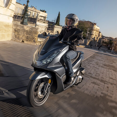Honda PCX125 met stedelijk landschap op achtergrond