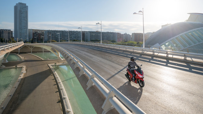 Honda PCX125 rijdend in stedelijke omgeving.