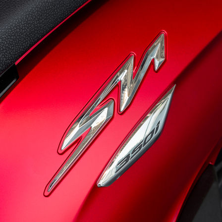 Honda SH350i, zoom op SH-logo, rode motor