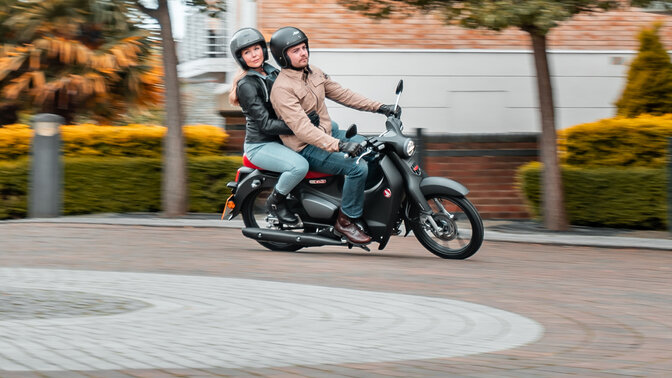 Honda Monkey op zijstandaard op de baan met rijder