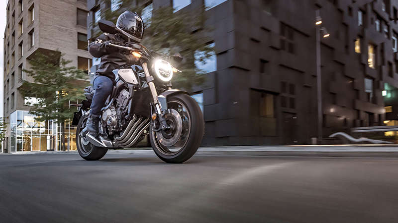 CB650R Neo Sports Café, driekwart rechtervooraanzicht met motorrijder, in de stad
