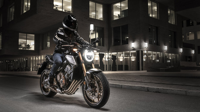 CB650R Neo Sports Café, driekwart rechtervooraanzicht met motorrijder, in de stad, in het donker